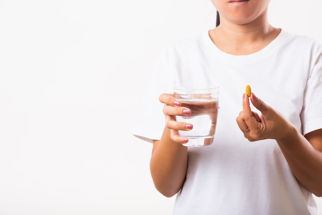 Frau halten Fischölvitamin-Drogen in der Hand mit einem Glas Wasser