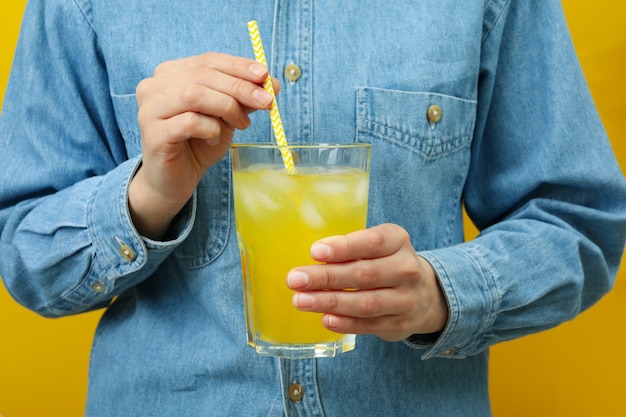 Frau halten Glas Soda auf gelber Wand