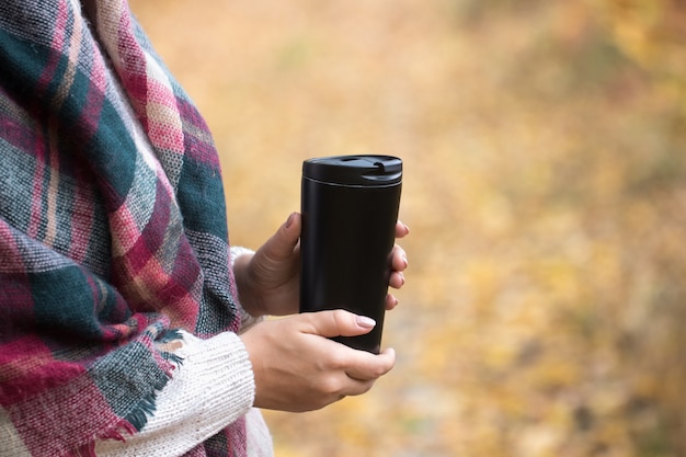 Frau halten Tasse im Wald, Herbstfoto