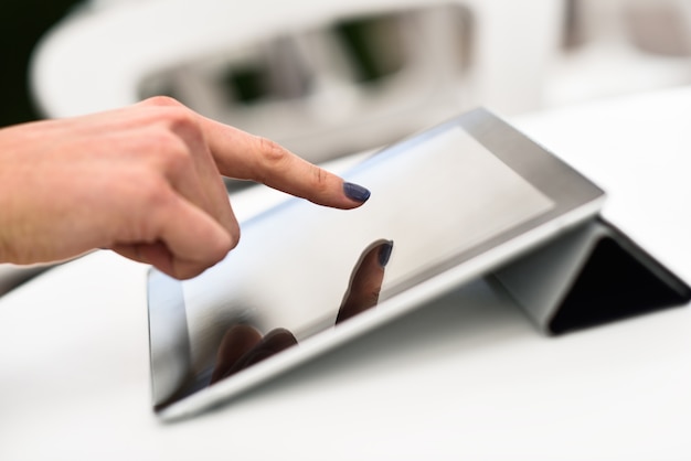 Foto frau hand berührt einen tablet-computer