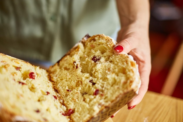 Frau Hand geschnitten Osterkuchen auf rustikalen Holztisch