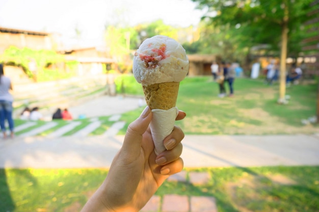 Frau Hand hält Wafer Kegel mit Beeren Eis