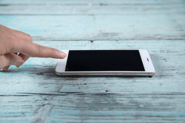 Frau Hand Smartphone auf dem Tisch