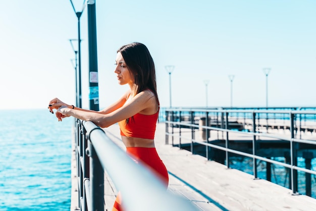 Frau hat Fitness im Freien vor dem Meer beendet