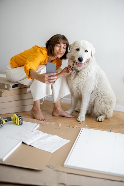 Frau hat Spaß mit ihrem süßen Hund beim Reparieren der Wohnung