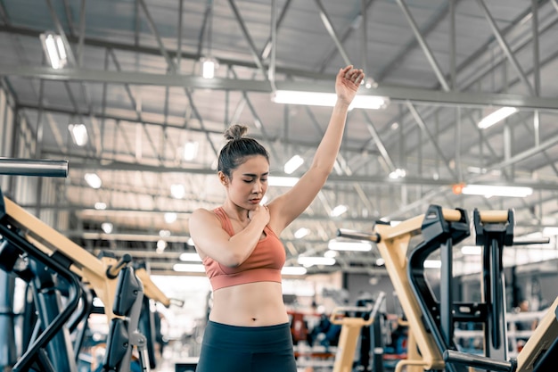 Frau hat Verletzungen und Schmerzen an den Armen während des Trainings und Krafttrainings im Muskelschmerzkonzept im Fitnessstudio