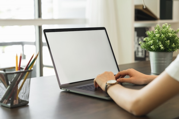 Frau hatte Laptop weißen Bildschirm und Briefpapier auf dem Tisch im Haus.