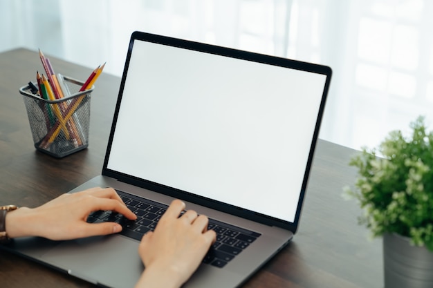 Frau hatte Laptop weißen Bildschirm und Briefpapier auf dem Tisch im Haus.