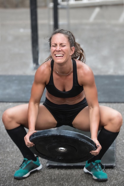 Frau hebt Gewichte bei einem Cross-Trainingswettbewerb