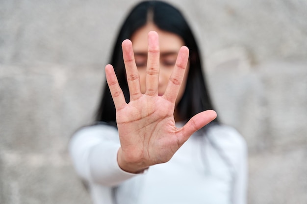 Frau hebt ihre Hand, um zu sagen, dass genug genug ist