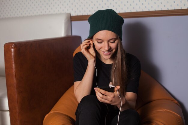 Frau Hipster hört Musik im Café