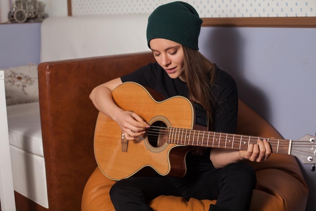 Frau Hipster spielt auf Gitarre und singt