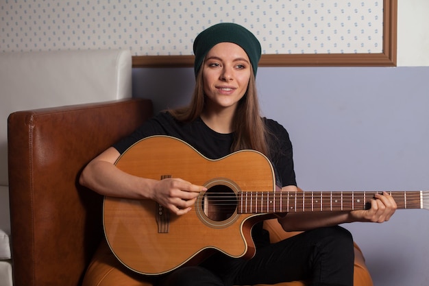 Frau Hipster spielt auf Gitarre und singt