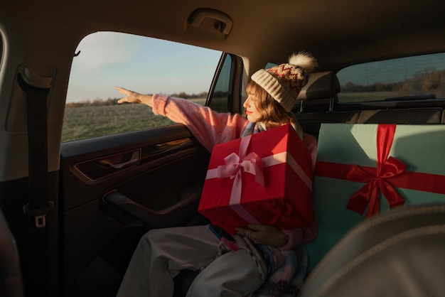 Frau im Auto mit Weihnachtsgeschenken