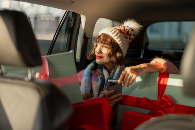 Frau im Auto mit Weihnachtsgeschenken