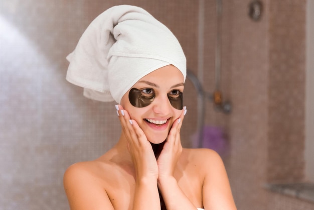 Frau im Badezimmer, die schwarze Augenflecken anwendet Hautpflege- und Spa-Morgenkonzept