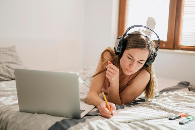 Frau im Bett, die eine Online-Klasse hat