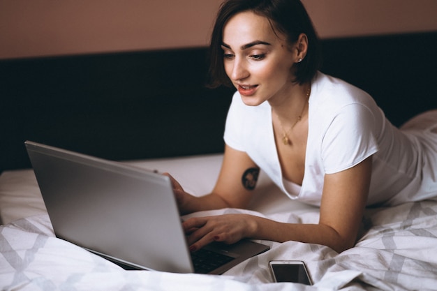 Frau im Bett mit Laptop