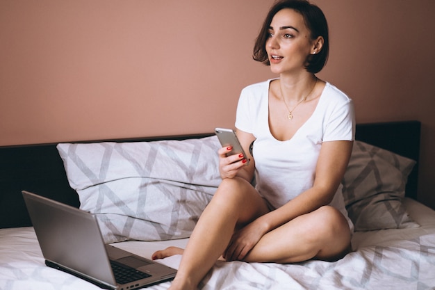 Frau im Bett mit Telefon