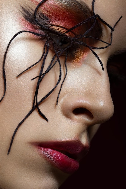 Frau im Bild der Spinne mit kreativem Kunst-Make-up-Schönheitsgesicht Nahaufnahme