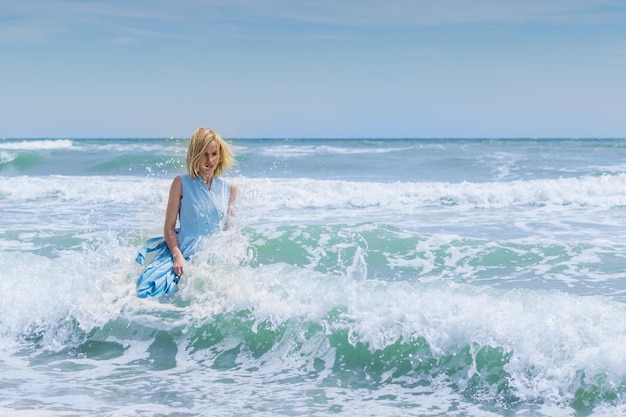 Frau im blauen Kleid im Wasser im Ozean das Meer