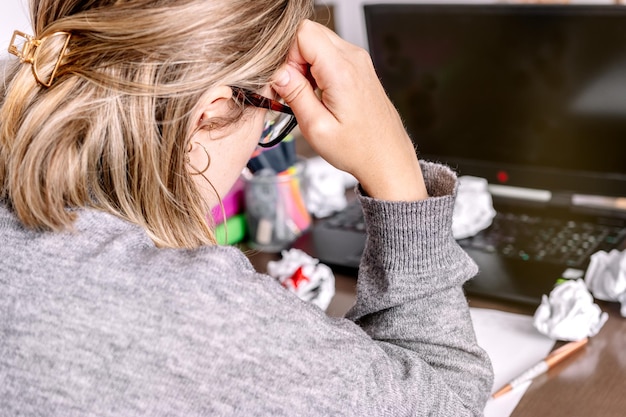 Frau im Büro mit vielen zerknitterten Papieren