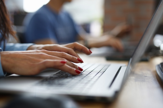 Frau im Büro tippt auf Tastatur