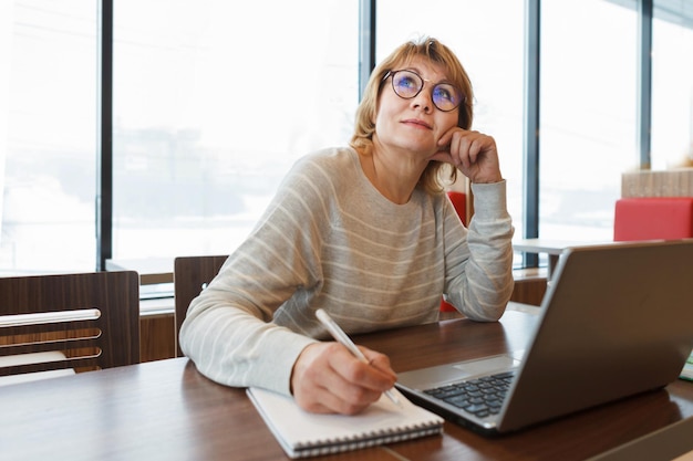 Frau im Café und Büro, die mit Laptop arbeitet