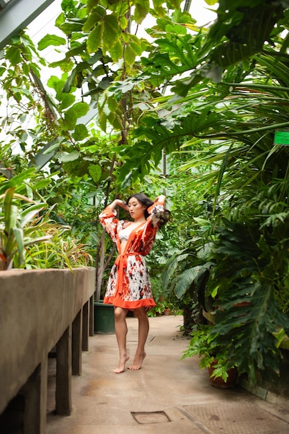 Frau im Garten des Resorts in leichter Sommerkleidung