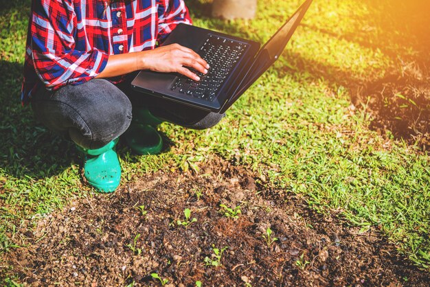 Frau im Garten mit dem Laptop