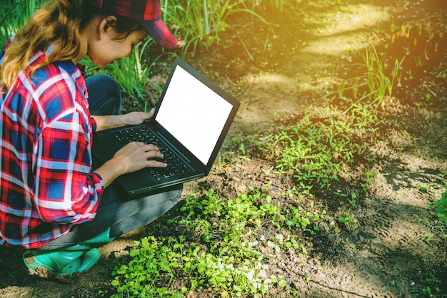 Frau im Garten mit dem Laptop