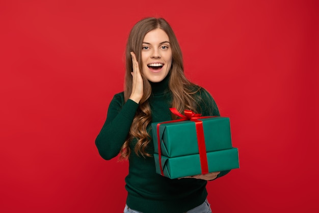 Foto frau im grünen pullover, der weihnachtsgeschenk hält und schreit