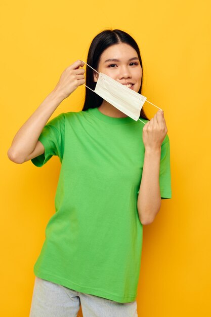 Frau im grünen T-Shirt medizinischer Maskenschutz isolierter Hintergrund unverändert