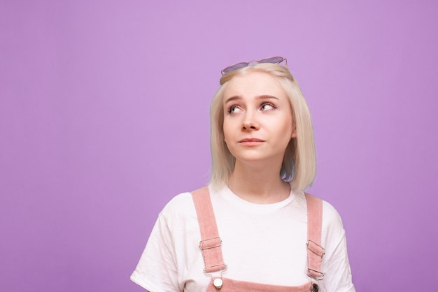 Frau im hellen lässigen Kleid, weißes T-Shirt und rosa Sonnenbrille tragend