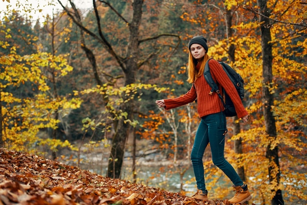 Frau im Herbstwald nahe Flusslandschaft verlässt den Tourismus