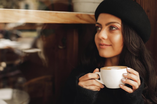 Frau im Hut mit Tasse Kaffee