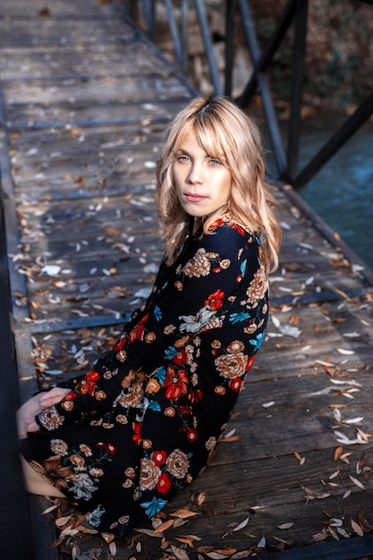 Frau im Kleid auf Holzbrücke