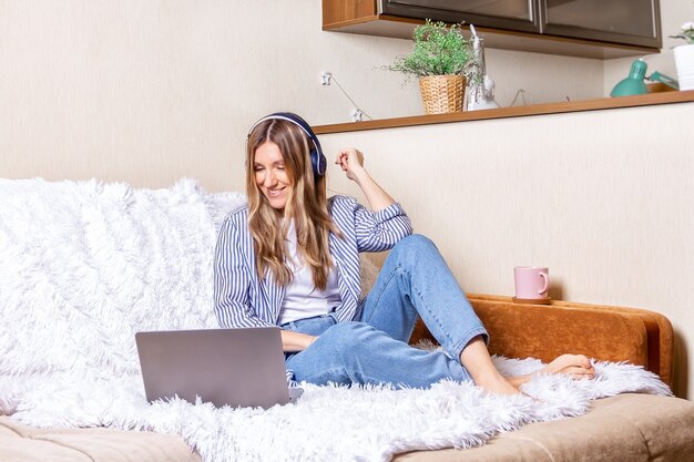 Frau im Kopfhörer mit Laptop