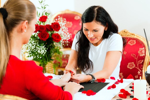 Frau im Nagelsalon, der Maniküre empfängt