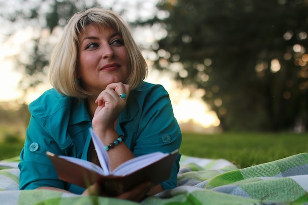 Frau im Park mit Buch auf dem Gras