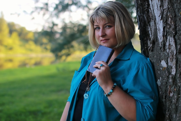 Frau im Park mit Buch auf dem Gras