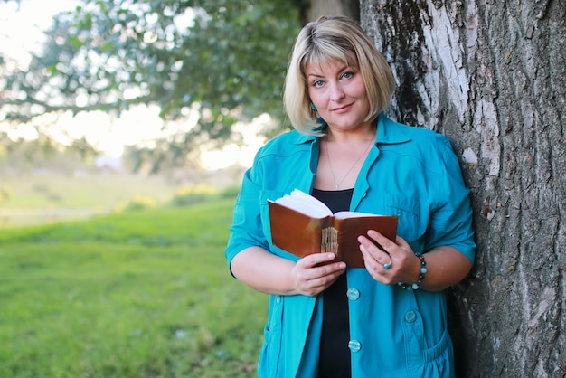 Foto frau im park mit buch auf dem gras