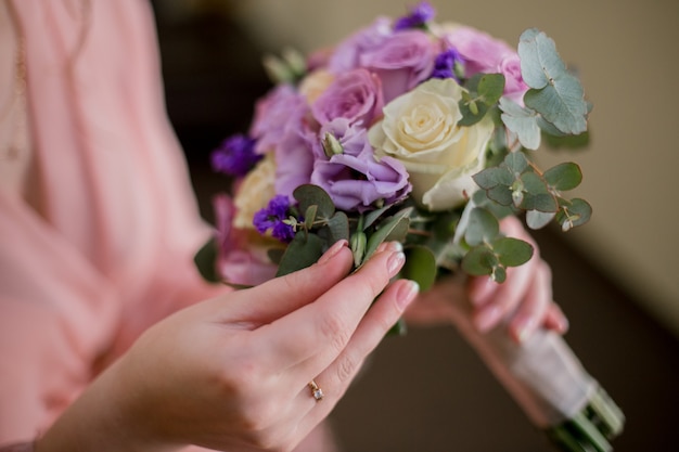 Frau im Peignoir mit Hochzeitsstrauß