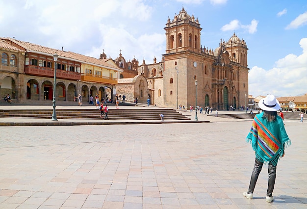 Frau im peruanischen Poncho Blick auf die Kathedrale von Cusco Peru