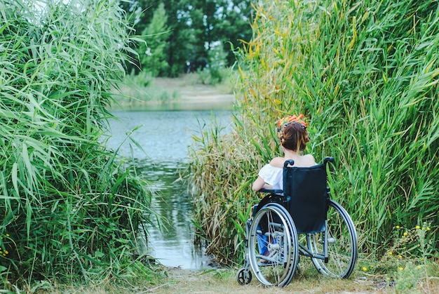 Frau im Rollstuhl, Zeit genießend, den See betrachtend