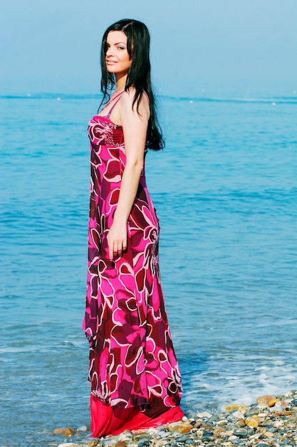 Frau im rosafarbenen Kleid am Meeresstrand