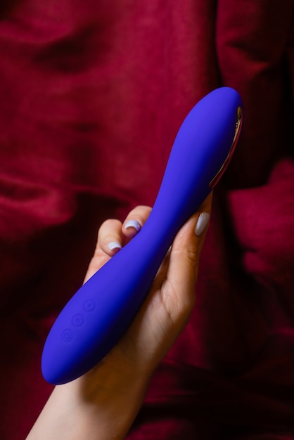 Frau im Schlafzimmer mit Vibrator in der Hand