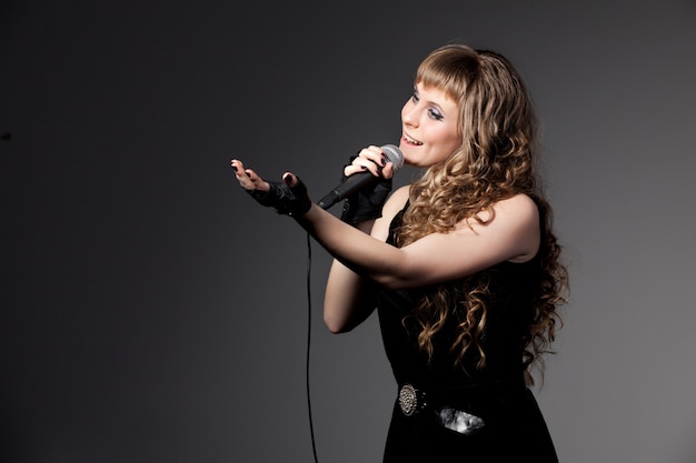 Foto frau im schwarzen kleid und handschuhe singen