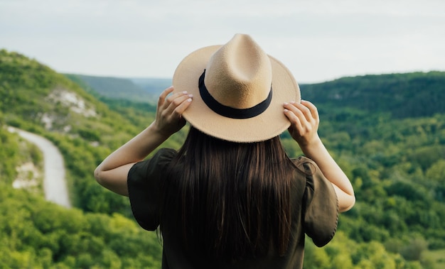 Frau im Sommerkleid und Hut reisen in den Bergen