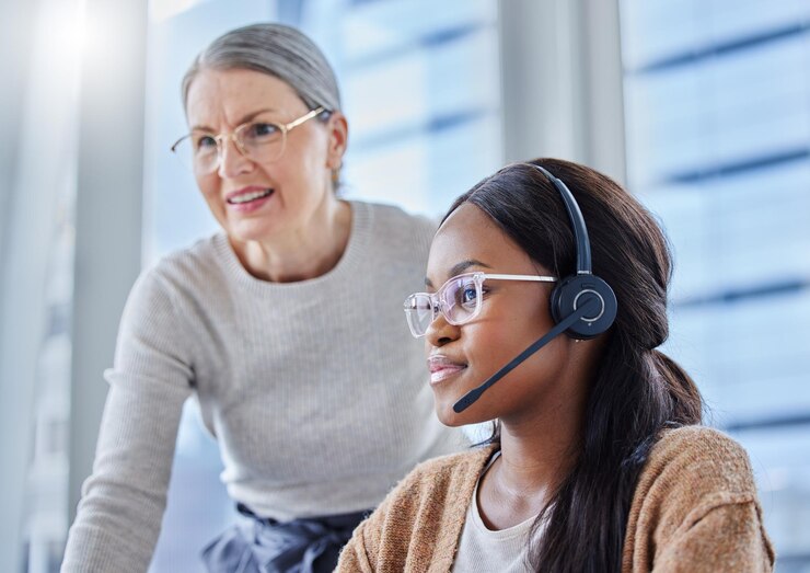 Foto frau im telemarketing und mentor, die bei der kundendienstarbeit hilft, technische unterstützung oder manager, reife person, chef und lehrmitarbeiter für callcenter, verkaufs- oder lösungsagentur oder kommunikation